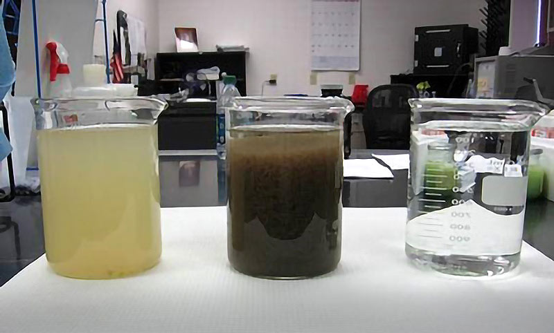 Containers of water showing the before, during and after the treatment process